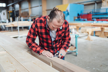Carpenter or joiner working with timber in a factory workshop