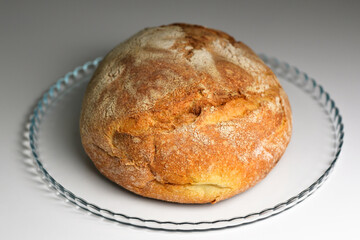 Round bread close-up. Freshly baked sourdough bread with a golden crust. Baker shop context with delicious bread. Pastry items.