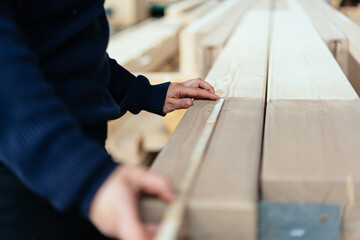 Hands of a carpenter or joiner taking measurements in a workshop