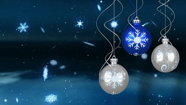 Animation of snowflakes falling over christmas baubles decoration in winter landscape
