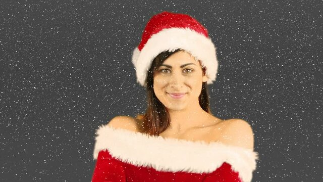 Animation of smiling woman wearing santa costume over snow falling