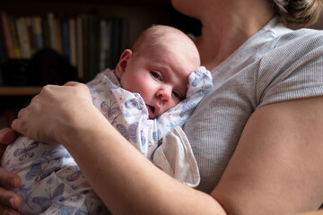 Caucasian mother holding her newborn baby girl spending time together
