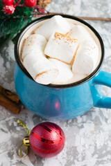 Delicious cocoa with cinnamon and marshmallows, christmas decor and gingerbread cookies on a light table top view from the top copy space.