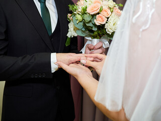 Obraz na płótnie Canvas Husband puts a ring on his wife's finger 