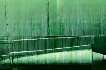 Sheathing of the metal side of an old submarine in green with welded seams