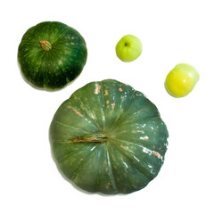 Green pumpkins and apples on a white background. Vegetables and fruits. Isolated image. Flat lay