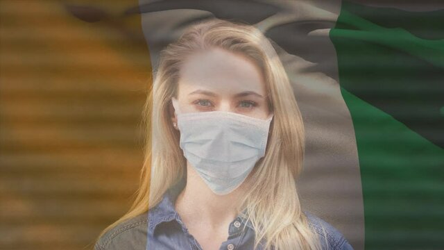 Animation of flag of ivory coast waving over woman wearing face mask during covid 19 pandemic