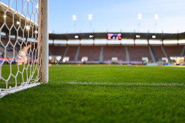 Net and the post in the football goal and stadium before match in the background.