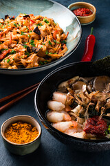Traditional Chinese or Thai food set. Chinese noodles, fried rice with chicken, tom yum soup,deep fried fish and udon with shrimps. Asian style food concept.