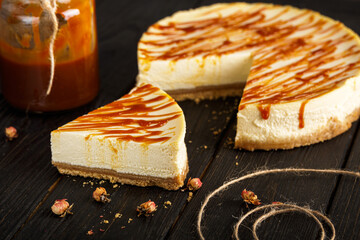 Cheesecake with caramel sauce on black background. Homemade caramel cheesecake.