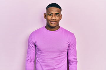 Young black man wearing casual pink sweater with a happy and cool smile on face. lucky person.