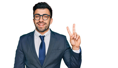 Hispanic man with beard wearing business suit and tie smiling with happy face winking at the camera...