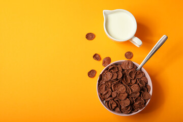 chocolate cornflakes for breakfast on colored background close up