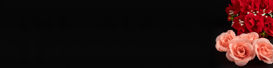 Closeup of the decorative bouquet of artificial red roses on the black background