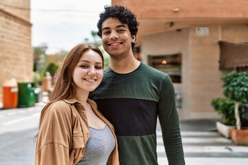 Young interracial couple smiling happy and hugging standing at the city.