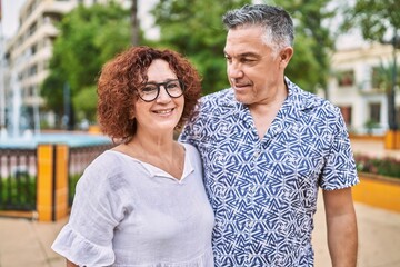 Middle age hispanic couple together outdoors on summer day