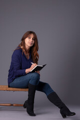 person with a book taking notes