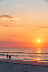couple walking on the beach during sunset