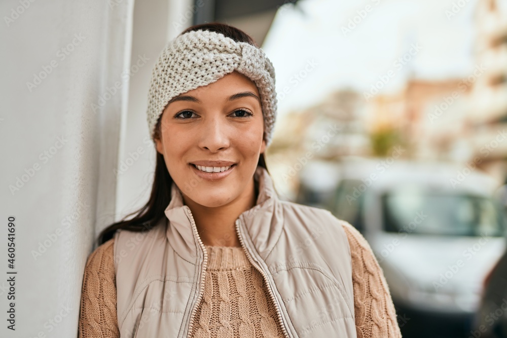 Sticker Young latin woman smiling happy standing at the city.