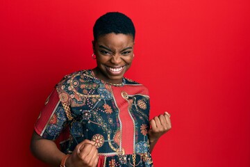 Young african american woman wearing african style excited for success with arms raised and eyes closed celebrating victory smiling. winner concept.