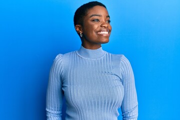 Young african american woman wearing casual clothes looking to side, relax profile pose with...
