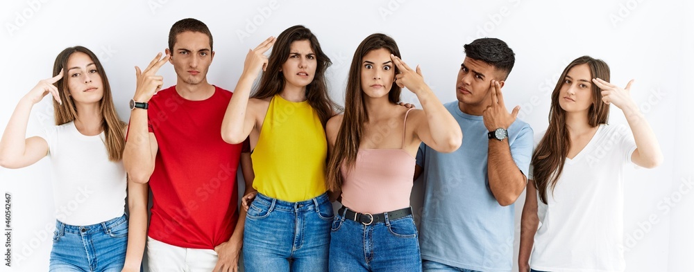 Canvas Prints Group of people wearing casual clothes standing over isolated background shooting and killing oneself pointing hand and fingers to head like gun, suicide gesture.