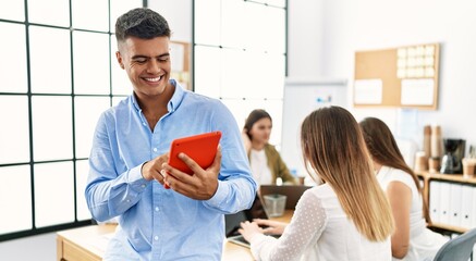 Group of business workers working sitting on the table. Man smiling happy and using touchpad standing at the office.
