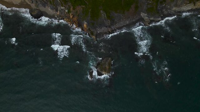 waves crashing on the island and beach with pebble
