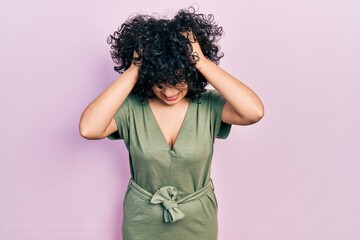 Young middle east woman wearing casual clothes suffering from headache desperate and stressed because pain and migraine. hands on head.