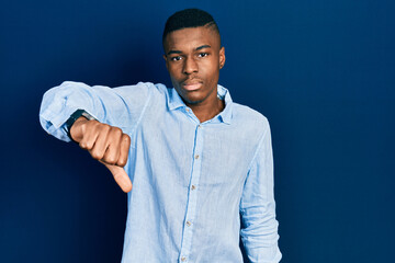 Young african american man wearing casual clothes looking unhappy and angry showing rejection and...