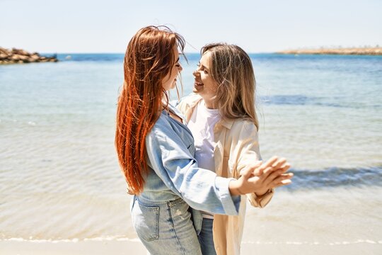 Young lesbian couple of two women in love at the beach. Beautiful women together dancing at the beach