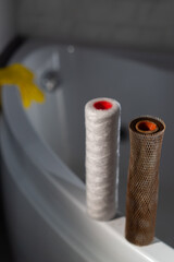 Filters for water. New clean and old dirty filter cartridge rusty.