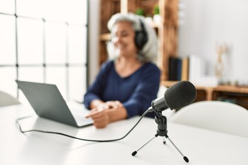 Fototapeta premium Middle age grey-haired woman smiling happy working at radio studio.