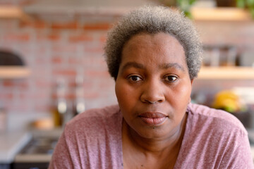 Portrait of serious african american senior woman it kitchen
