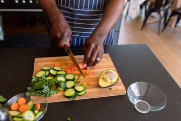 Hands of african american senior man cooking in kitchen