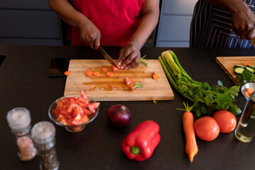 Hands of african american senior couple cooking together in kitchen