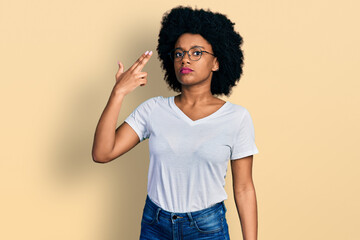 Young african american woman wearing casual white t shirt shooting and killing oneself pointing hand and fingers to head like gun, suicide gesture.