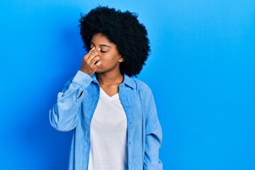 Fototapeta na wymiar Young african american woman wearing casual clothes tired rubbing nose and eyes feeling fatigue and headache. stress and frustration concept.