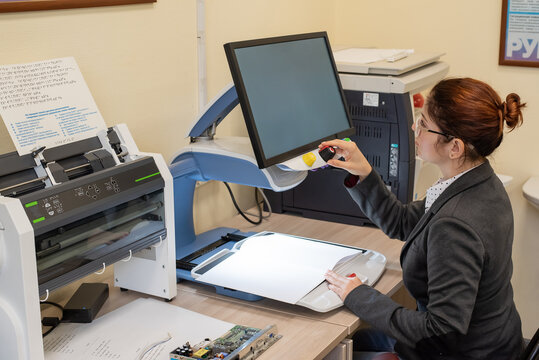 A Visually Impaired Woman Uses Special Reading Equipment