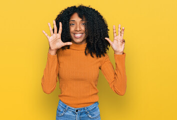 Young african american girl wearing casual clothes showing and pointing up with fingers number nine...