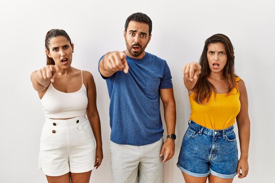 Group of young hispanic people standing over isolated background pointing displeased and frustrated to the camera, angry and furious with you