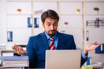 Young male employee sitting at workplace