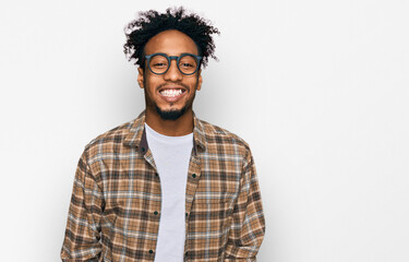 Fototapeta premium Young african american man with beard wearing casual clothes and glasses with a happy and cool smile on face. lucky person.