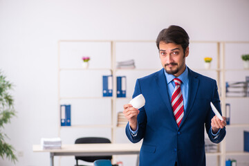 Young male employee drinking coffee during break