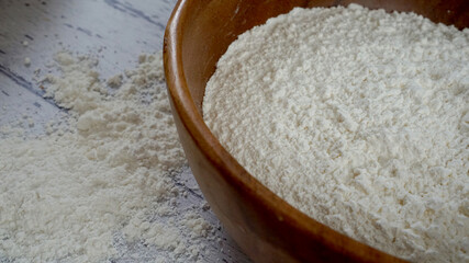 木製のボールに入った小麦粉と周りに散らばった小麦粉