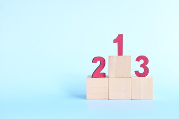 Podium, ranking and hierarchy concept. Wooden blocks with numbers 123 in blue background.