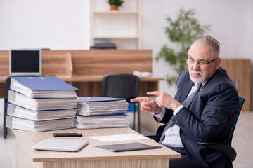 Aged male employee sitting at workplace