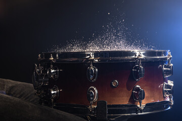 Close-up, snare drum on dark background with stage spotlight.