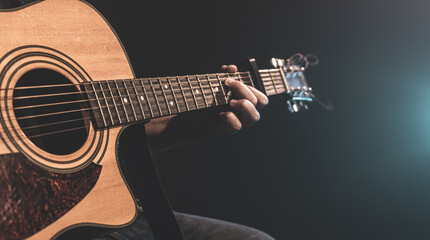 Close-up shot of guitarist playing acoustic guitar, copy space.