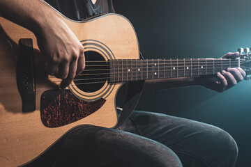 Fototapeta premium Close-up shot of guitarist playing acoustic guitar, copy space.